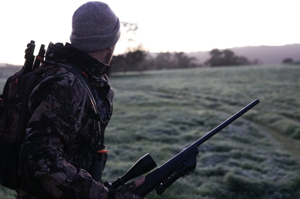 hunter walking forest dawn back view